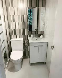 Un baño con inodoro, lavabo y espejo. en Loft II en Madrid, en Madrid