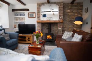 Una sala de estar con un sofá y una chimenea. en Derwen House Newport, Pembrokeshire, en Newport