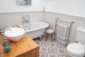 Un baño con bañera, inodoro y lavabo. en Derwen House Newport, Pembrokeshire, en Newport 23 fotos más