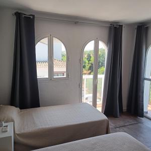 a bedroom with two beds and two windows at Duquesa Harbour Club Aparthotel in Manilva