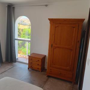 a bedroom with a wooden cabinet and a window at Duquesa Harbour Club Aparthotel in Manilva