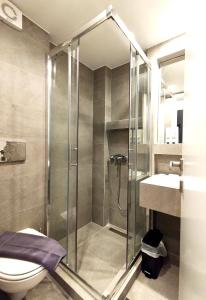 a bathroom with a shower and a toilet and a sink at Marelia Urban in Thessaloniki +25 photos