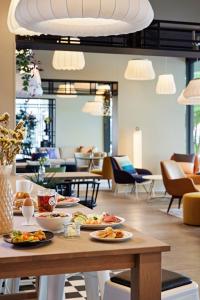 a table with plates of food on it in a restaurant at LÉGÈRE EXPRESS Tuttlingen in Tuttlingen