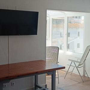 a table with a flat screen tv on a wall at Duquesa Harbour Club Aparthotel in Manilva