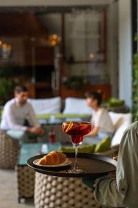 a person holding a tray with a drink and bread at Holiday Inn Telavi by IHG in Telavi