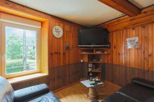 a living room with a tv and a window at Maison Bateau in Plouézec