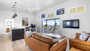 un soggiorno con un divano e un tavolo di Altitude - Pet-Friendly, Romantic, Accessible a Coffs Harbour