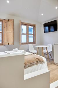 a white bedroom with a bed and a table at Casa Beltane in A Coruña