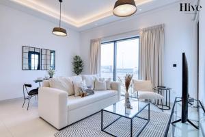 迪拜7 By Aurora 101的白色的客厅，配有白色的沙发和桌子