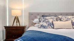 a bedroom with a bed with a lamp and pillows at Beachfront by the CC - Plunge Pool, Beach, Pets, 3Bed, 3Bath in Sapphire Beach