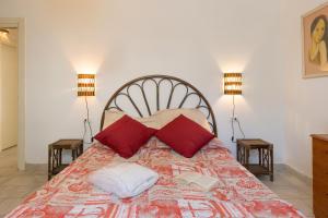ein Schlafzimmer mit einem Bett mit roten Kissen und zwei Lampen in der Unterkunft Villa Corallo Sofia in San Vincenzo