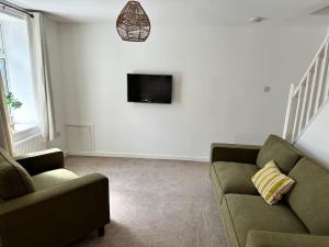 un soggiorno con un divano e una TV di Stylish miners cottage at North Rd a Porth
