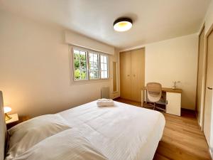 a bedroom with a large white bed and a window at Belle maison, 15mn de Paris, 2 parkings gratuits in Cachan