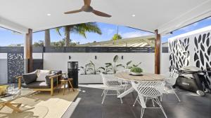 a patio with a table and chairs and a grill at Ellie's Holiday Escape - Pool, Romantic, Fireplace in Coffs Harbour