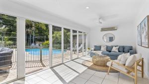 un soggiorno con divano e una piscina di Fairways Beach House - Pool, Golf, Sawtell Village, Family Friendly a Sawtell Altre 16 foto