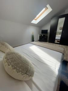 a large white bed with pillows in a bedroom at Enjoy Apartments - Central Skylight Residence in Cluj-Napoca