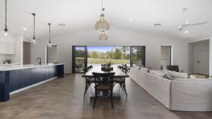 a kitchen and living room with a table and a couch at Koala Lane - Family, Pool, Sleeps 10, Luxe in Bonville