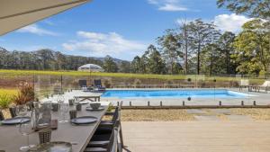 an outdoor dining area with a table and a swimming pool at Koala Lane - Family, Pool, Sleeps 10, Luxe in Bonville +16 photos