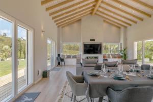 a living room with a table and chairs and a tv at Vale de Agua in Aljezur