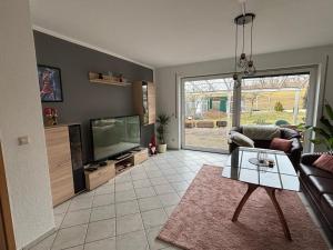 a living room with a couch and a tv at Ferienwohnung Heike in Hilbersdorf
