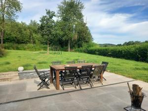 Grez-DoiceauMaison d'hôte的一张木桌和椅子,后面是田野