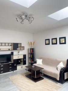 a living room with a couch and a table at Enjoy Apartments - Central Skylight Residence in Cluj-Napoca
