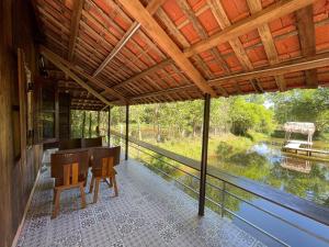 a screened porch with a desk and a view of a river at Thôn Hoa Sen in Thôn Xuân Lỗ