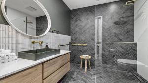 a bathroom with a sink and a mirror at Luxe Jetty Apartment - Stylish, Walk to Beach & Cafes in Coffs Harbour