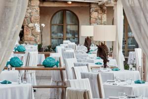 a banquet hall with white tables and chairs at La Villa Del Re - Adults Only - Small Luxury Hotels of the World in Castiadas