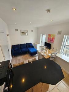 a living room with a table and a blue couch at City Centre Stay Apartment in Galway +6 photos