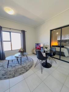 a living room with two tables and a bed at Sweet Snuggle Sanctuary in Boksburg