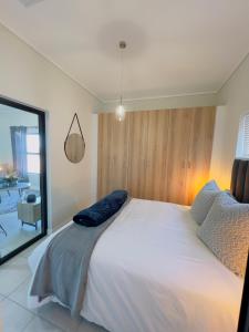 a bedroom with a large white bed and a window at Sweet Snuggle Sanctuary in Boksburg