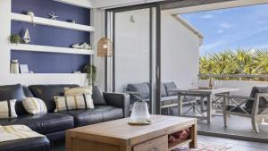 una sala de estar con un sofá y una mesa en Pacific Piers - Walk to Cafes, Pub & Jetty Beach, en Coffs Harbour