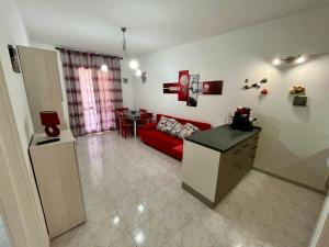 a living room with a red couch and a table at LE DUNE Casa vacanze Salento Puglia in Torre dell'Orso +38 photos