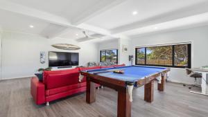 翡翠海滩Pandanus At Emerald - Prime Beach Location, Cafes的客厅设有台球桌和红色沙发。