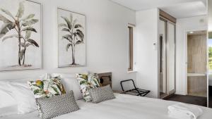 a bedroom with a white bed with two pillows at Penthouse 3804 - Rooftop Spa, Oceanview, Beach in Coffs Harbour
