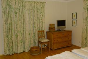 ein Schlafzimmer mit einem Bett und einem TV auf einer Kommode in der Unterkunft Ferienwohnung Grünwald in Eben im Pongau
