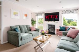 a living room with two couches and ametiki sign on the wall at Stunning 4 Bedroom House in Central Bath in Bath