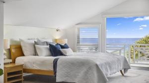 a bedroom with a bed with a view of the ocean at Hampton on the Beach - Stunning Beach Front, Sleeps 8 in Sapphire Beach