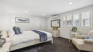 a bedroom with a bed and a chair and a mirror at Hampton on the Beach - Stunning Beach Front, Sleeps 8 in Sapphire Beach +16 photos