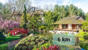 un giardino con una casa e un ponte sopra uno stagno di Villa SESCA - Piscine grande terrasse a Tolosa