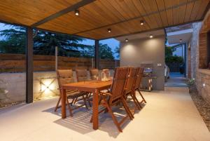 Una mesa y sillas de madera en un patio. en Beautiful Villa Baraka with pool near Pazin, en Kanfanar