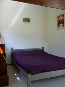 Bett in einem Schlafzimmer mit lila Daunendecke in der Unterkunft Le Nid du Lac, appartement en duplex au bord du lac d'Annecy, résidence avec plage privée in Doussard