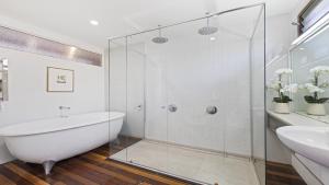 a bathroom with a glass shower and a tub and sink at Victoria's - Hamptons Beachside Residence in Emerald Beach +16 photos