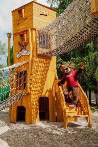 a person in a teddy bear standing on a wooden stairs at Rodinný Hotel Hubert High Tatras in Vysoké Tatry +64 photos
