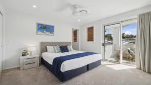 a bedroom with a bed and a balcony at Seas the Day - Modern Townhouse in Sawtell Village in Sawtell +16 photos