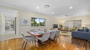 ein Esszimmer und ein Wohnzimmer mit Tisch und Stühlen in der Unterkunft Sea Pine Cottage - In the heart of Sawtell Village, Sleeps 6 in Sawtell