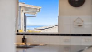 - Baño con espejo y vistas al océano en Ballantrae 8 - Walk To Beach & Cafes Sawtell Village, en Sawtell