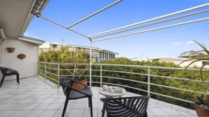 Un patio con sillas y una mesa en un balcón. en Ballantrae 8 - Walk To Beach & Cafes Sawtell Village, en Sawtell