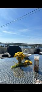 a table with a vase with yellow flowers on it at Flott sørlandshus ved sjøen leies ut in Arendal +3 photos